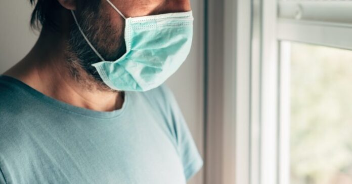 Depressed man with protective mask in self-isolation quarantine during virus outbreak pandemic Depressed man with protective mask in self-isolation quarantine during virus outbreak pandemic