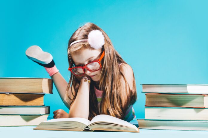 Little girl sitting by the books, studying. Little girl sitting by the books, studying.