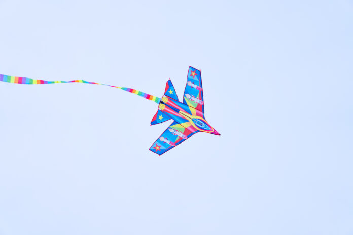 A color kite flying against a blue sky.
